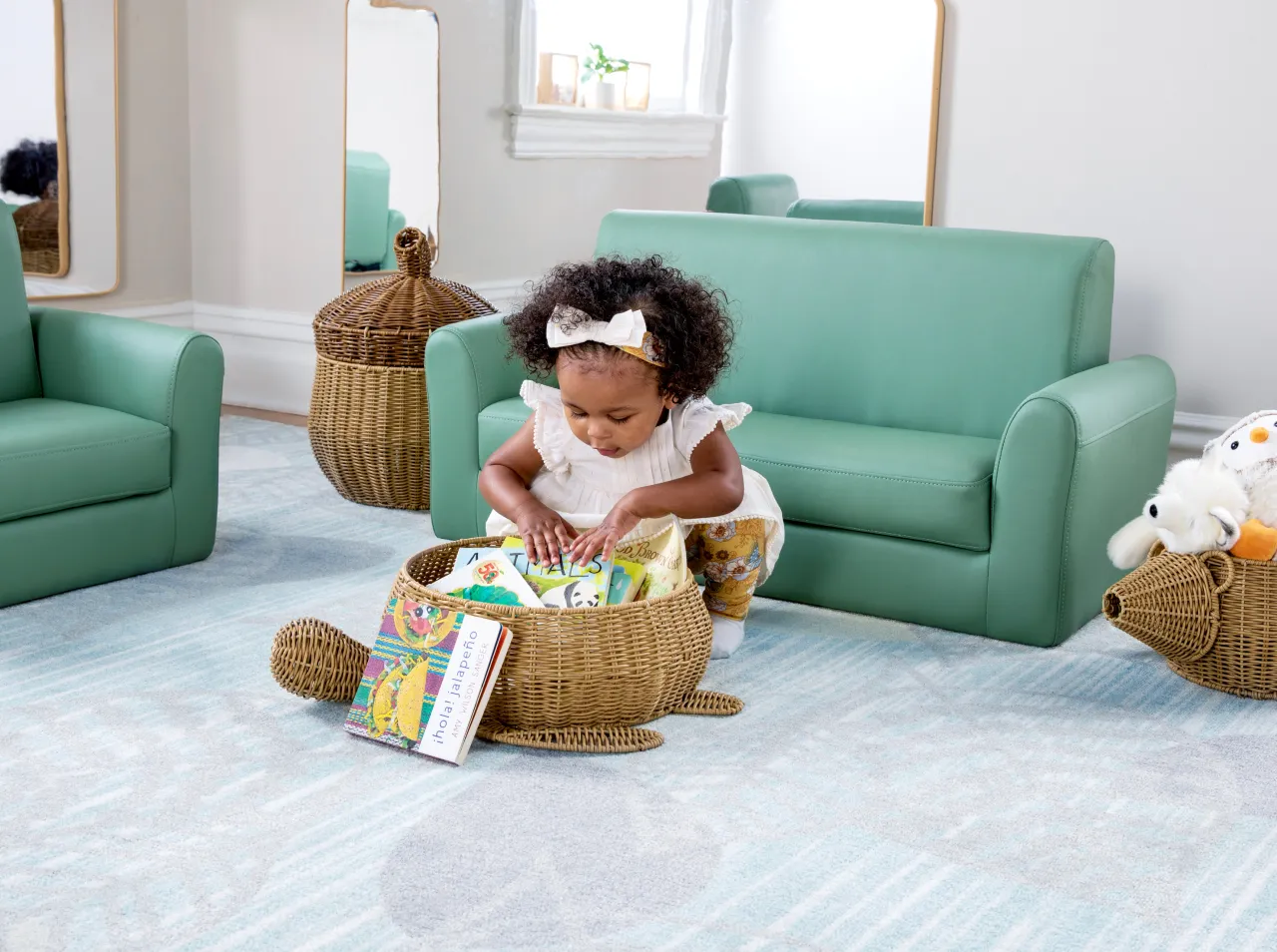 Toddler on the floor shuffling through a basket filled with picture books