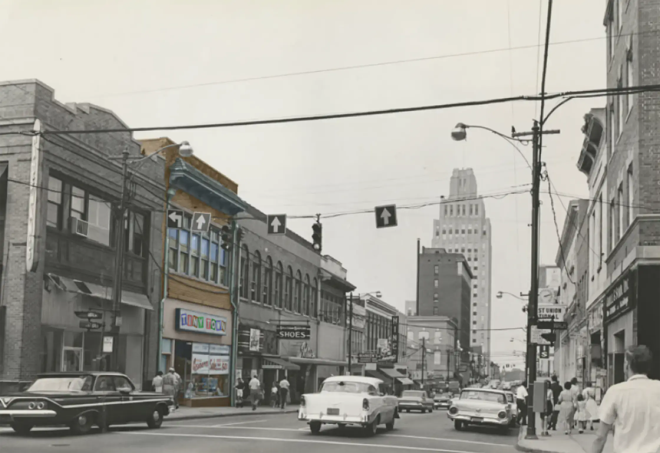 Old photograph of downtown Winston-Salem, NC, showing the Tiny Town building in the foreground highlighted in color