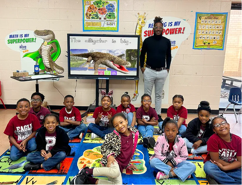 Preschool classrooom with children and teacher showing a screen with Alive Studios