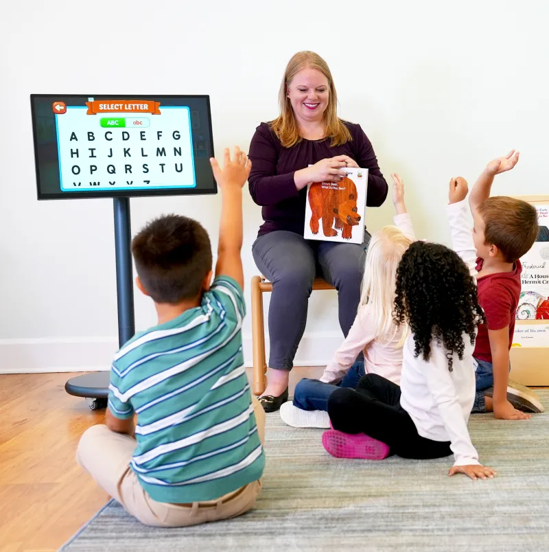 Teacher with Muv Pro mobile screen showing a picture to children