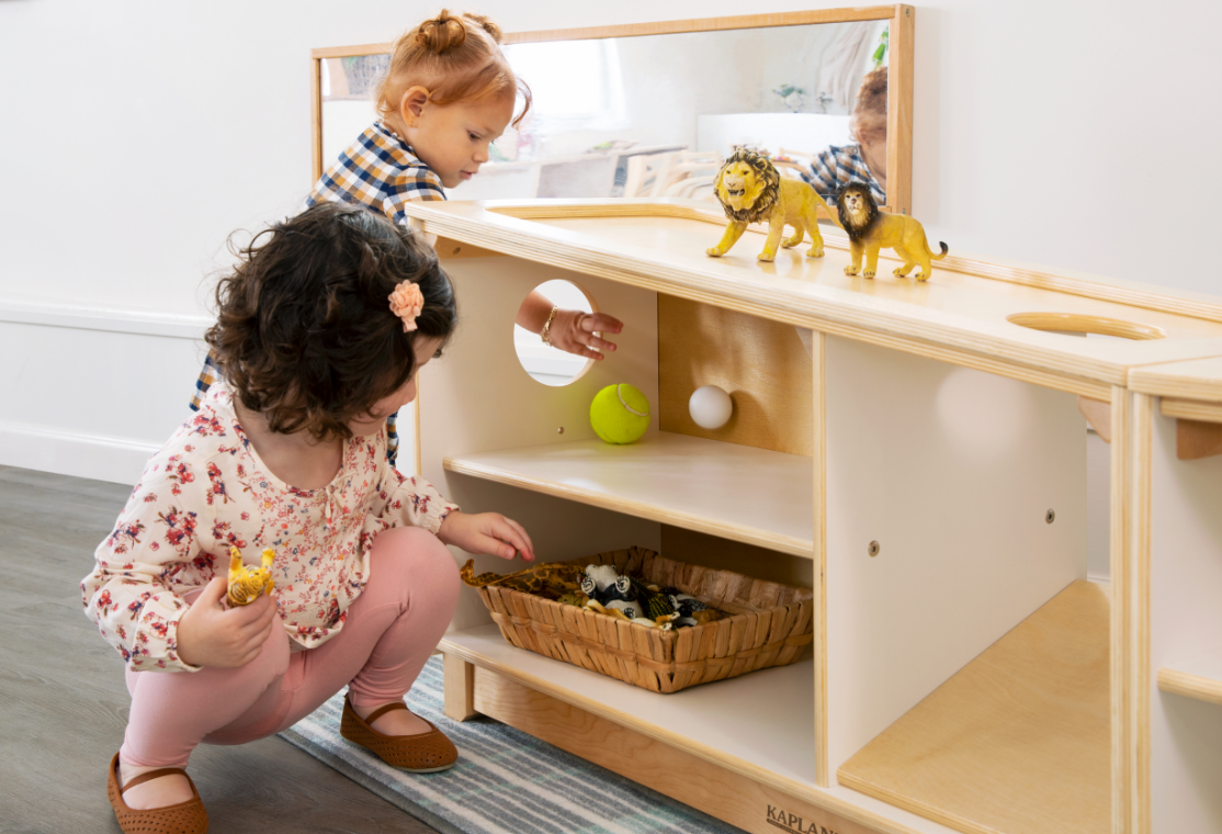 Two children playing around the Angled Storage unit