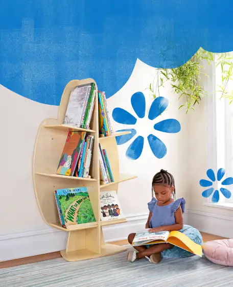 Child on the floor reading in front of the 3 Tier Tree Bookshelf