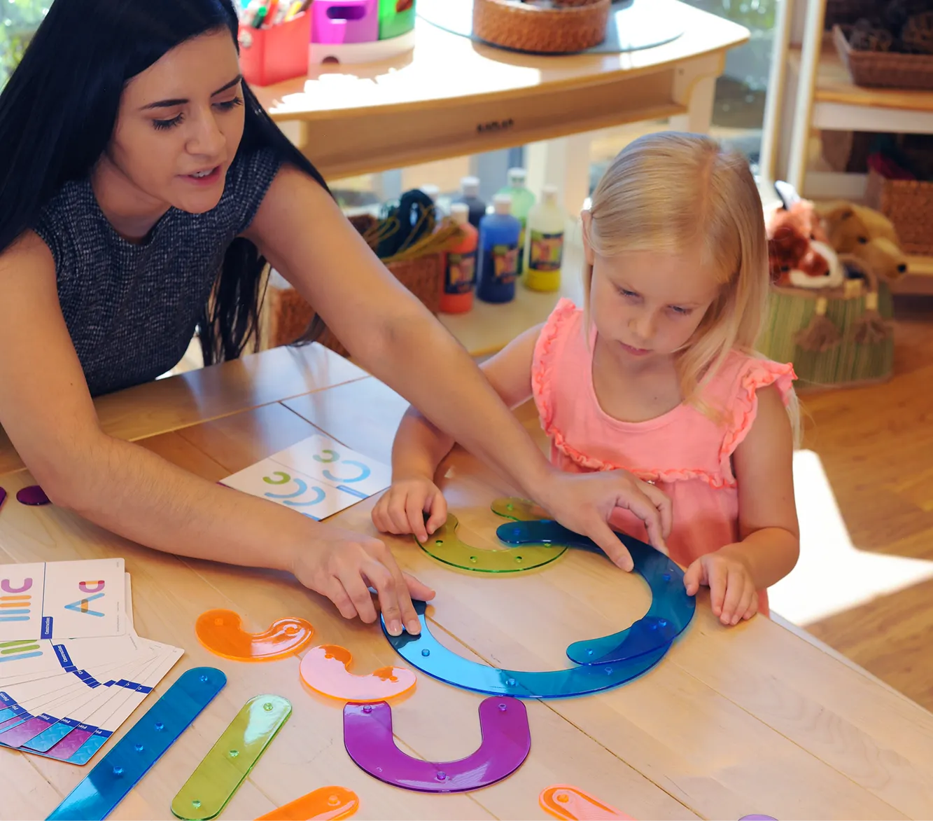 Teacher using curriculum to teach children in a preschool classroom