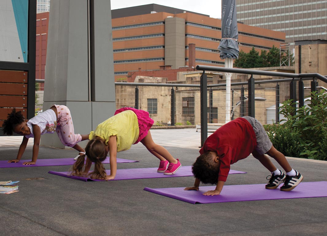 Children doing yoga outside on Purple Yoga Mats