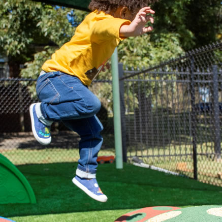 Child Jumping on Synthetic Grass