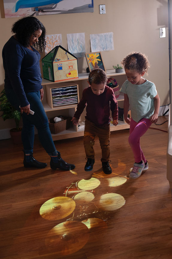Floor projection includes activities for music, math, science, and more