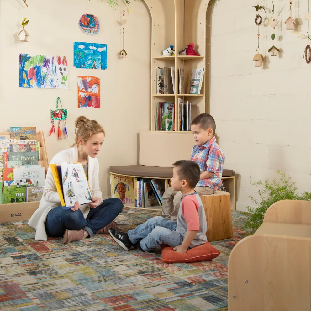 Preschool teacher reading a picture book to children