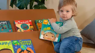 Toddler child grabbing a book