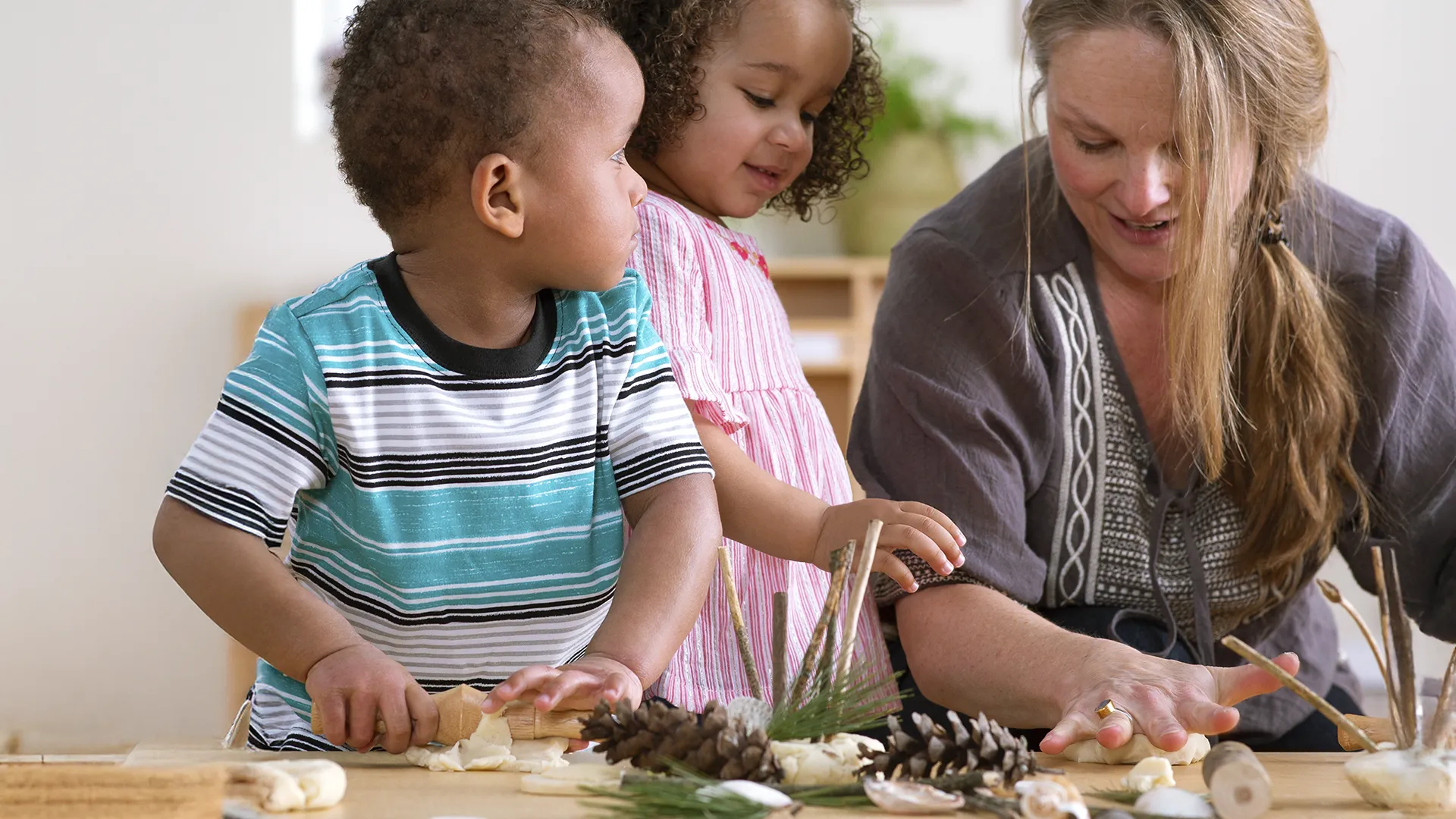 Children and teacher playing with nature items in a classroom