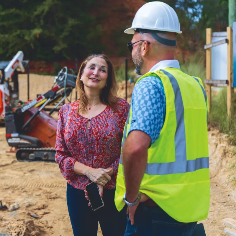 Construction worker talking to a woman at a playgraound installation site