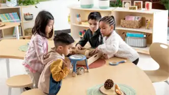 Children in a classroom doing an activity while sitting around a table