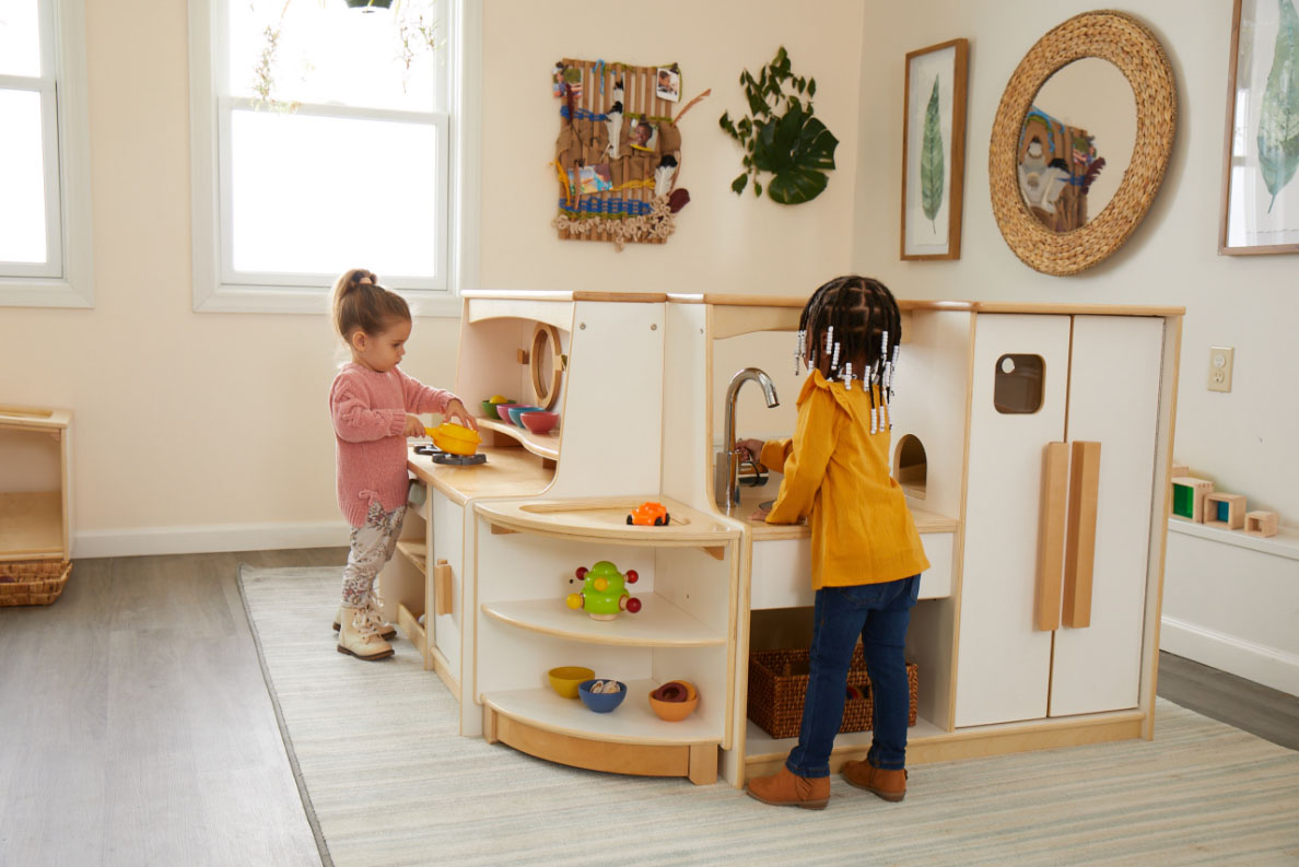Children playing around Sink and Fridge unit and Stove and Cupboard unit