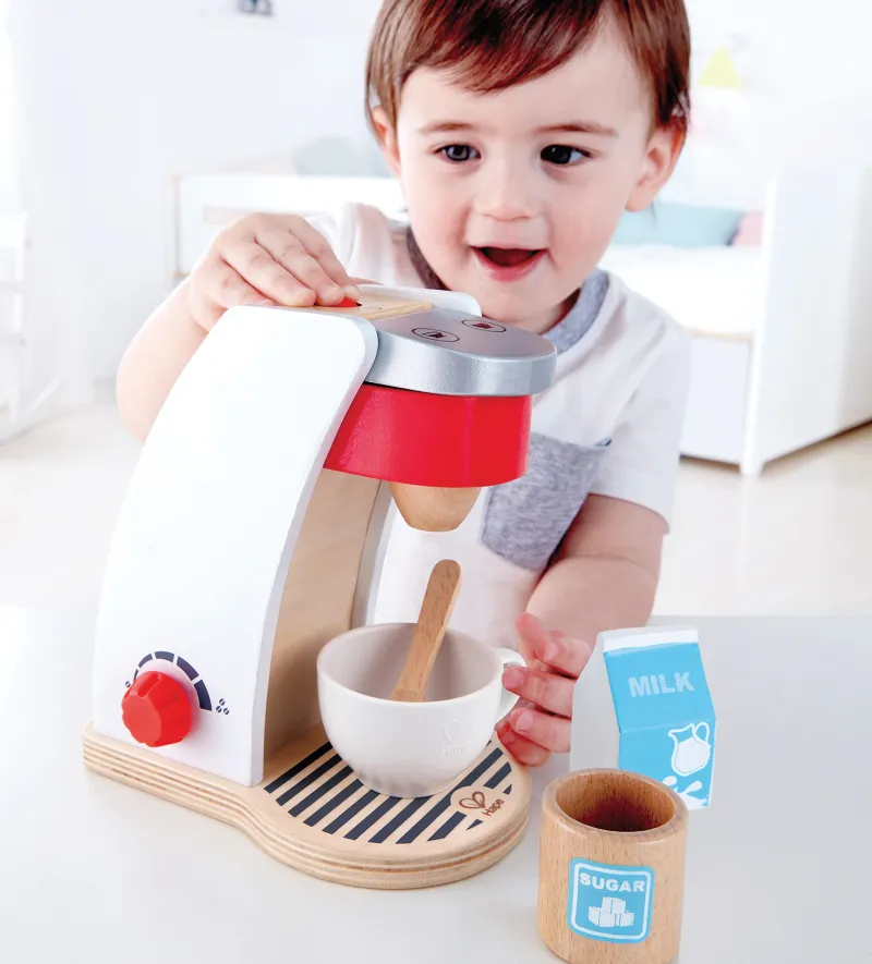 Child playing with toy coffee maker