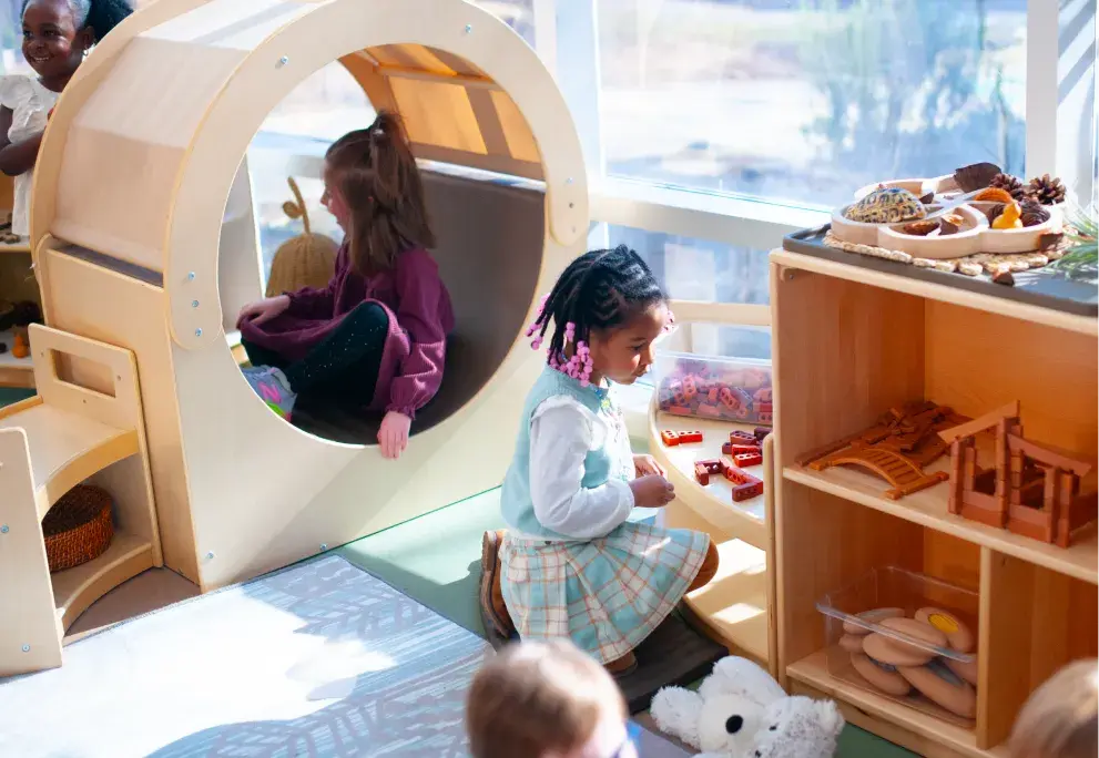 Girl playing with colorful blocks on a curved light table