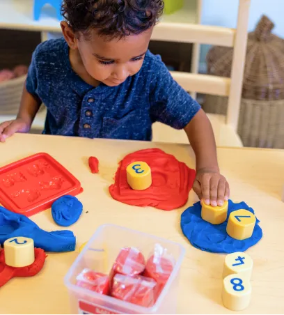 Young boy playing with blocks with numbers on them