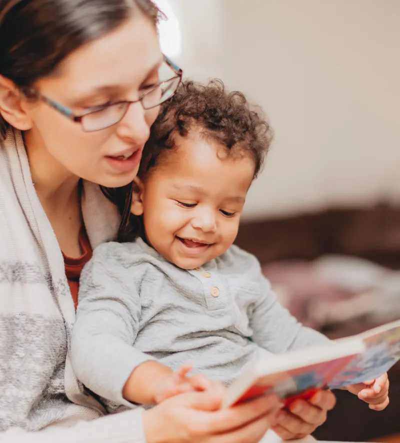 Young girl playing with a stuffed dog toy in a toy stroller