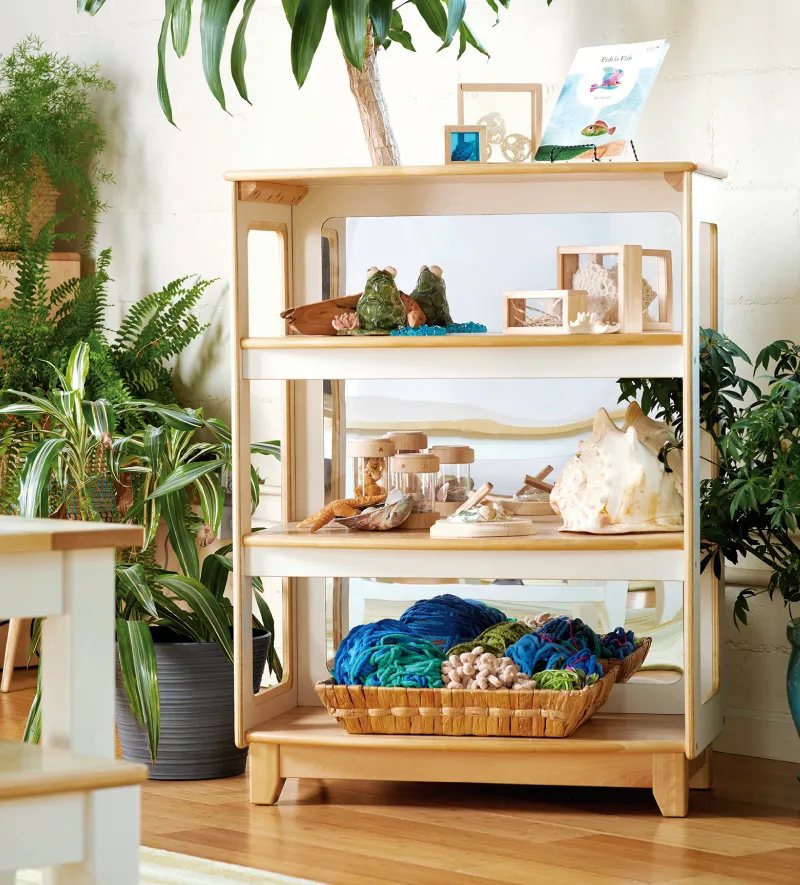 Three shelf storage unit with baskets and toys on it