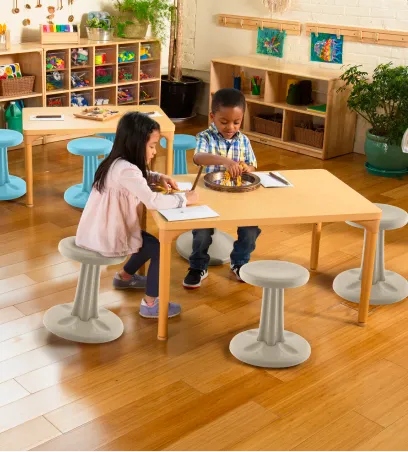 Children in a preschool classroom sitting at a table working on activities
