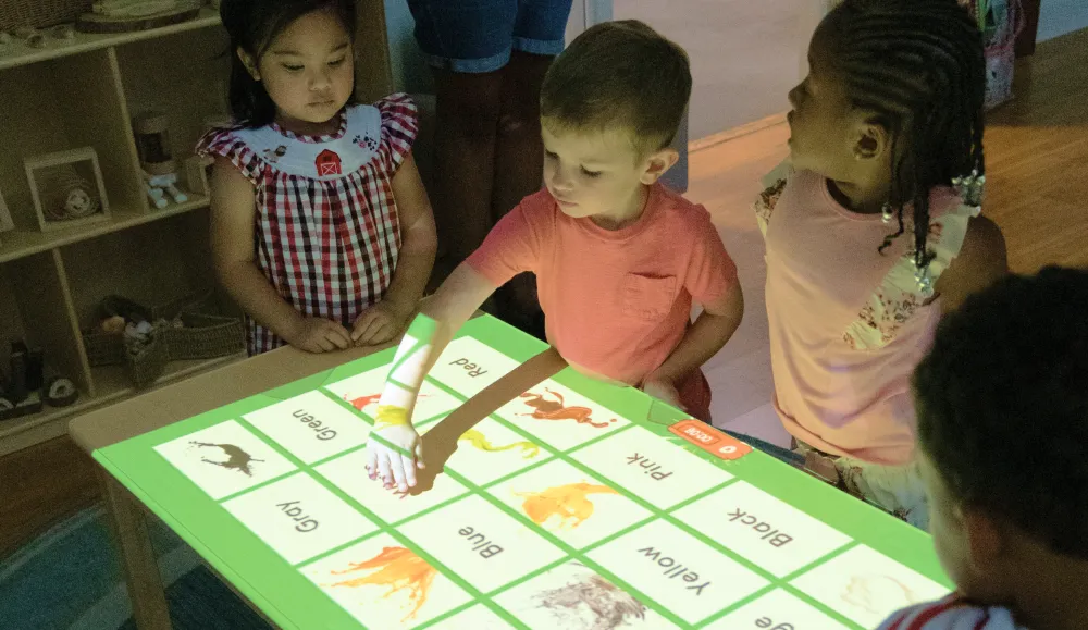 Children interacting with a game projected on a large table