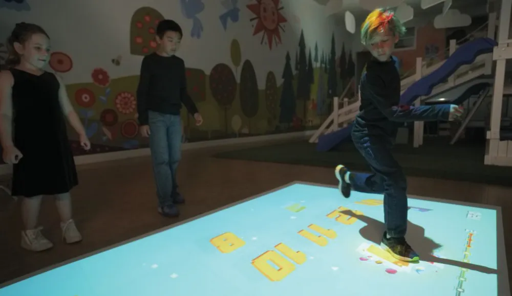 Children interacting with a game projected on the floor