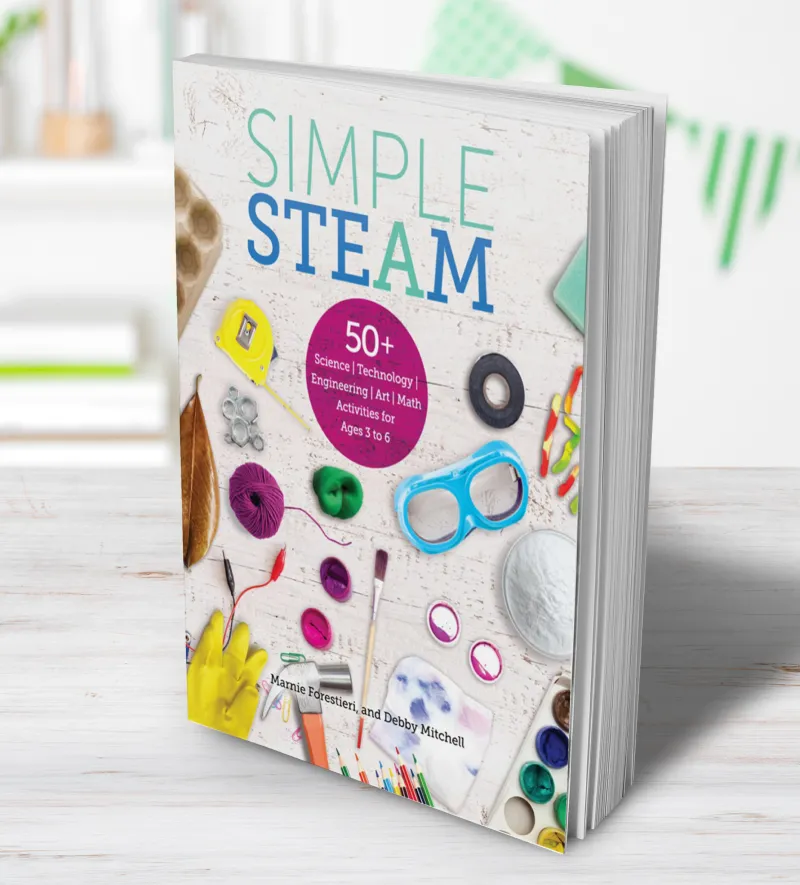 Child on a colorful carpet in a classroom reaching into a basket of soft toys