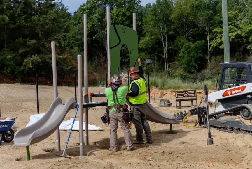Construction workers assembling playground equipment