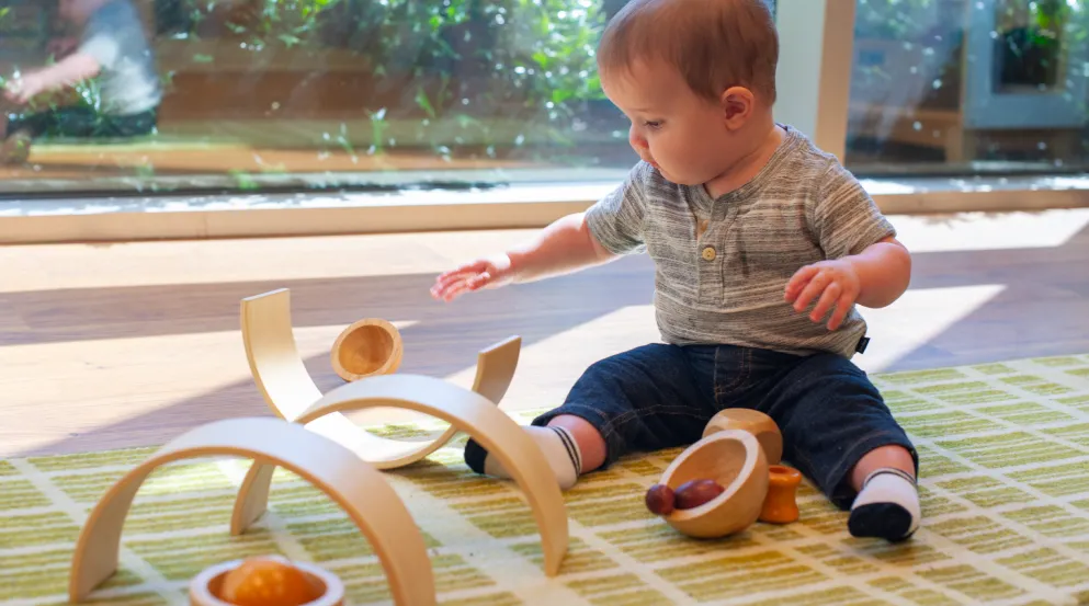 Baby playing with wooden arch blocks