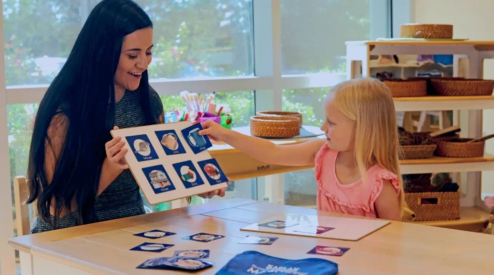 Preschool teacher with child using object cards