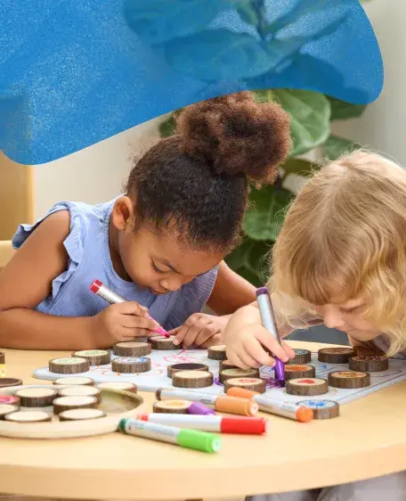 Two children playing with Magnetic Write-On Wood Cookies