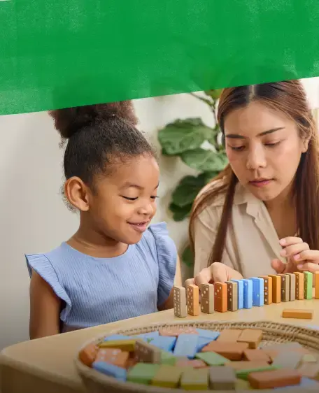 Adult and child playing with wooden dominoes